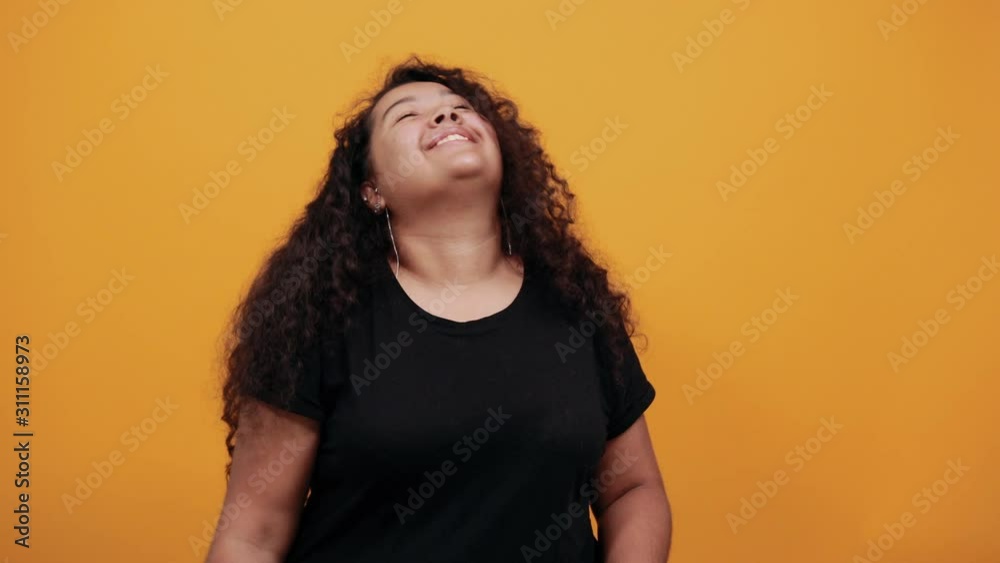 Charming afro-american woman showing three fingers at camera over isolated orange background wearing fashion black shirt. People lifestyle concepte. Charming afro-american woman showing three fingers at camera over isolated orange background wearing fashion black shirt. People lifestyle concepte.
