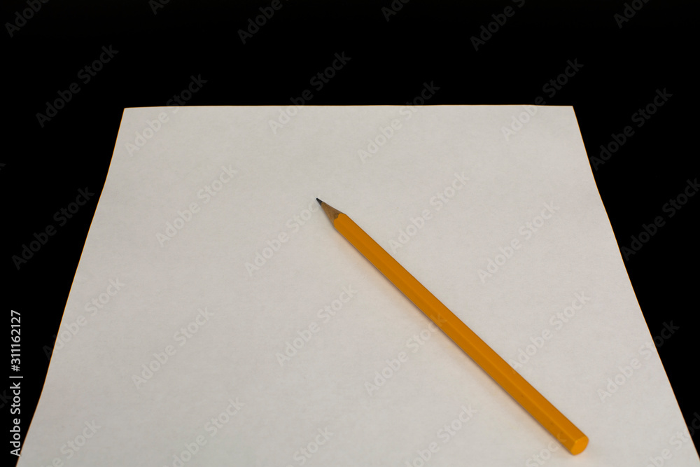 Yellow pencil on a white sheet of paper Yellow pencil on a white sheet of paper