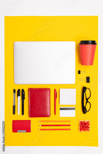 School and office supplies lie neatly on a yellow background