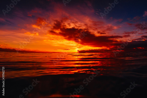 Quiet sea with warm sunset or sunrise colors. Bright sky and ocean