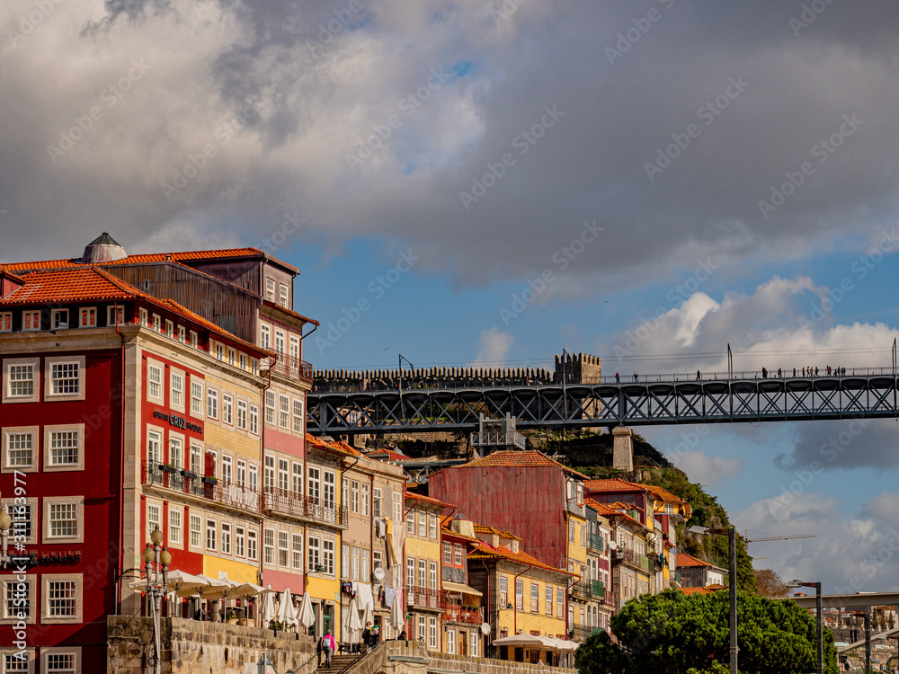 Porto, Portugal. 15 November 2019. People walking on Luis I bridge above the roofs of harborfront houses.