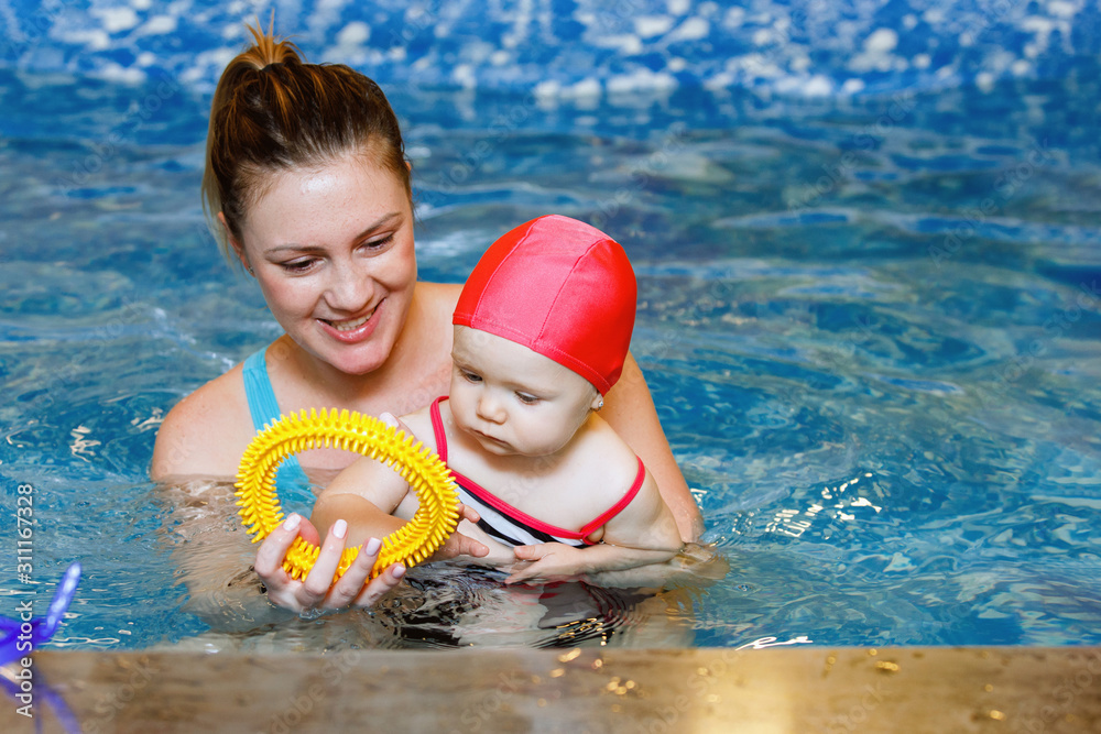 Female and child swim in water pool.