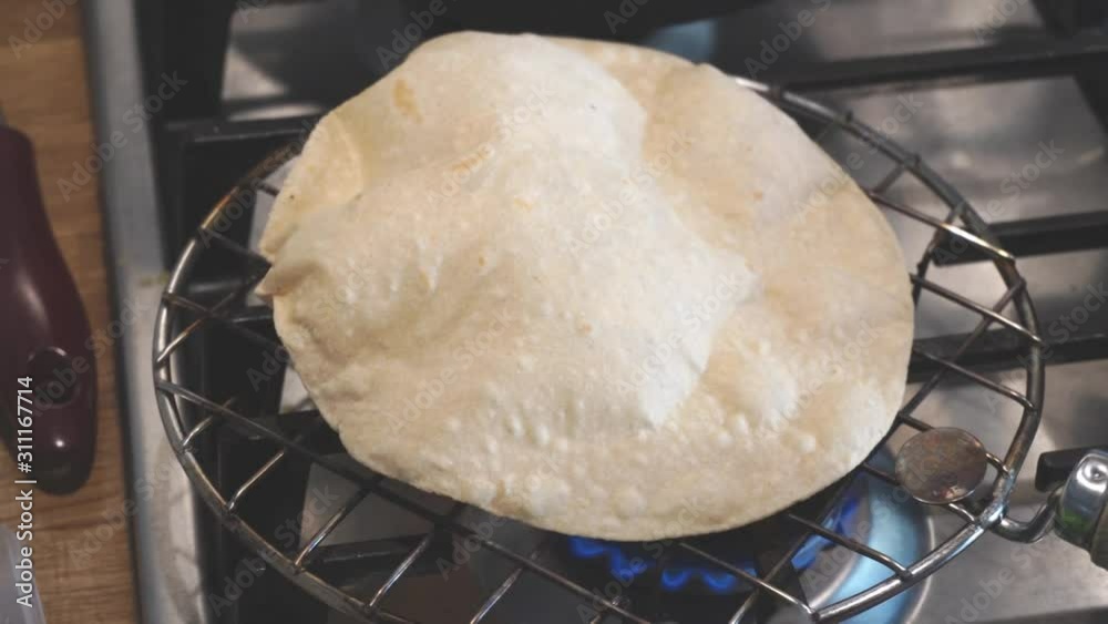 preparation of bread according to the Indian recipe. naan, chapati, poori. Fragrant flat Indian chapati breads with a light nutty aftertaste of whole grain flour. baking on open fire on grill.