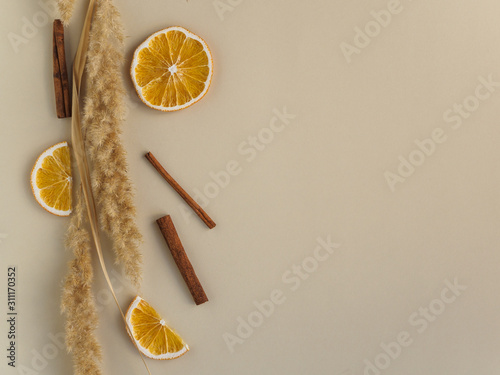 Dried oranges, flowers and cinnamon on a yellow background. Copy space