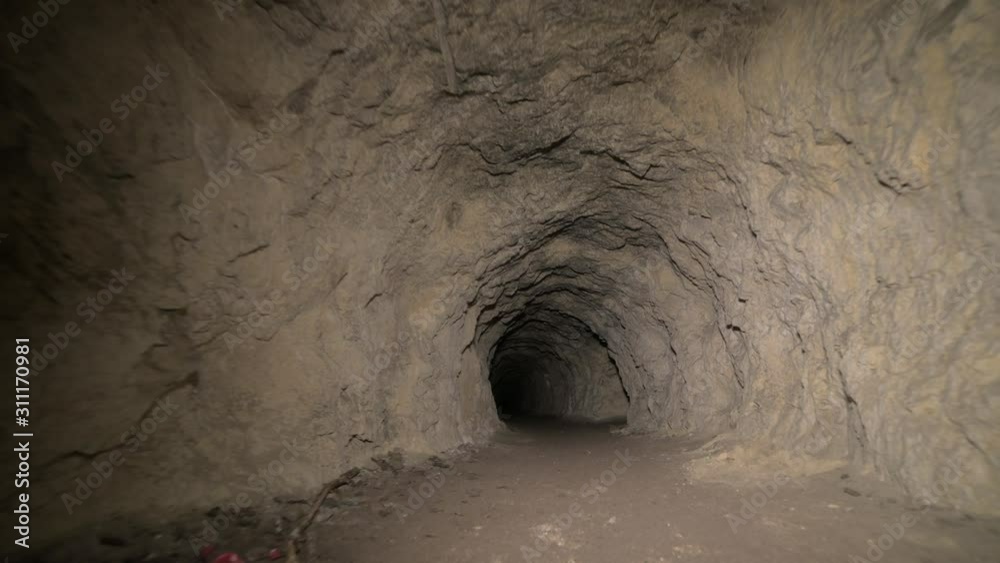 Speleology artificial cave dark tunnel excavation underground. Old adit ...