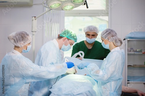 Team of surgeons doing surgery © olgasparrow
