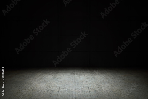 Dark empty room with black background and dim light on concrete floor