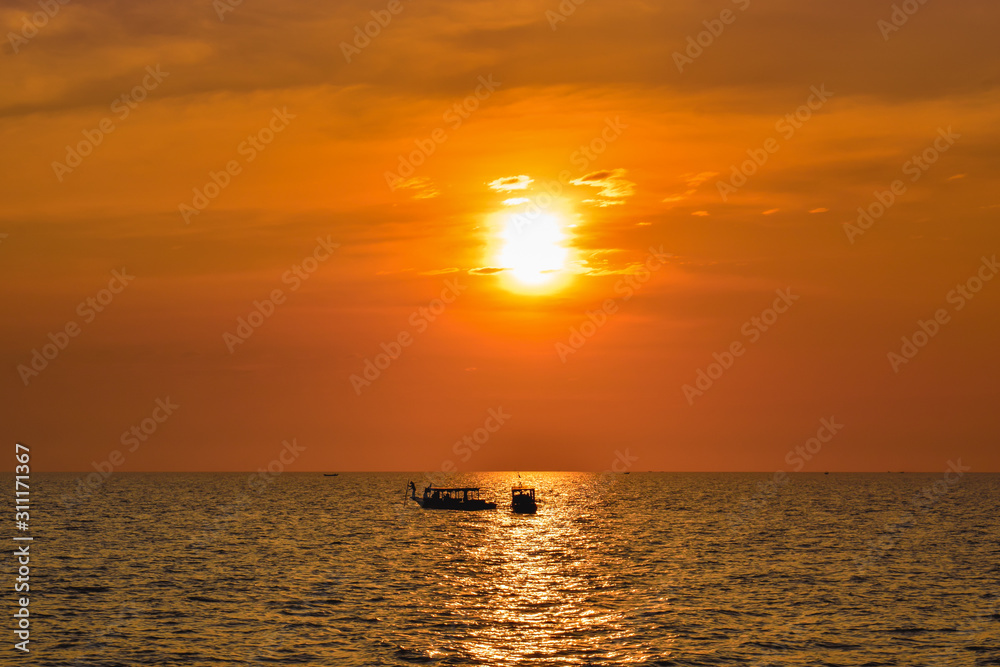 Two lonely ships on a wide ocean during beautiful orange sunset in Asia
