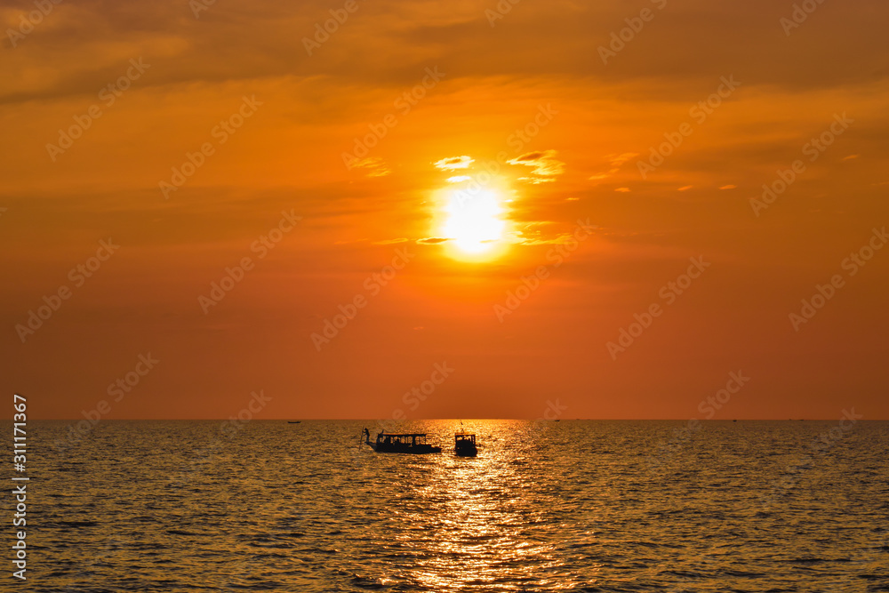 Two lonely ships on a wide ocean during beautiful orange sunset in Asia Two lonely ships on a wide ocean during beautiful orange sunset in Asia