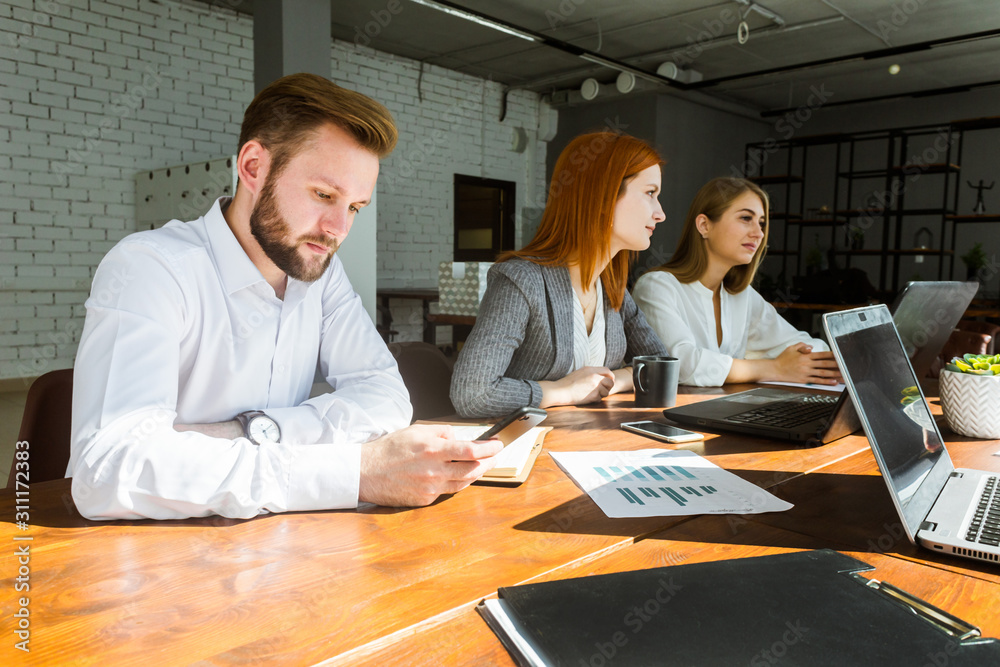 A team of young businessmen working and communicating together in an office. Corporate businessteam and manager in a meeting. A team of young businessmen working and communicating together in an office. Corporate businessteam and manager in a meeting.
