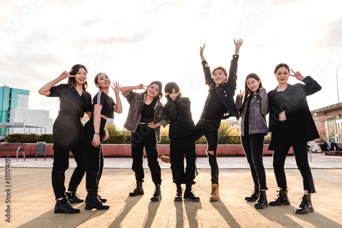 Young Asian team happy looking at camera. Chinese teenage friends at sunset photo