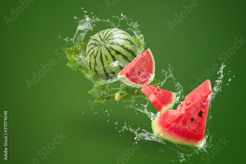 Water splashing on Sliced of watermelon on green background photo