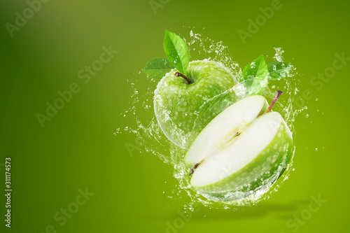 Fototapete Water splashing on Fresh green apple on Green background