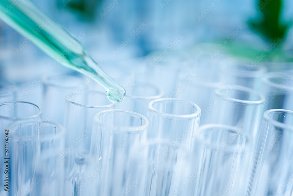Dropper over test tube dropping sample chemical into sample herbal plaint , biotechnoloy research concept.Natural extracts Dropper over test tube dropping sample chemical into sample herbal plaint , biotechnoloy research concept.Natural extracts