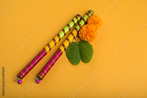 Indian Festival Dussehra and Navratri, showing golden leaf (Bauhinia racemosa) and marigold flowers with Dandiya sticks. photo