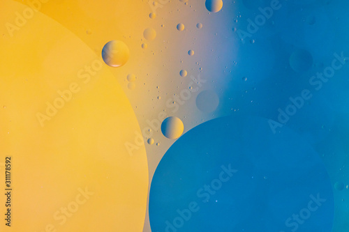An abstract artistic close up macro photo created by mixing oil and water then back lit with a blue and orange flash