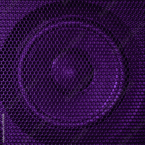 A close up macro photo of a speaker lit with a vibrant purple flash gel