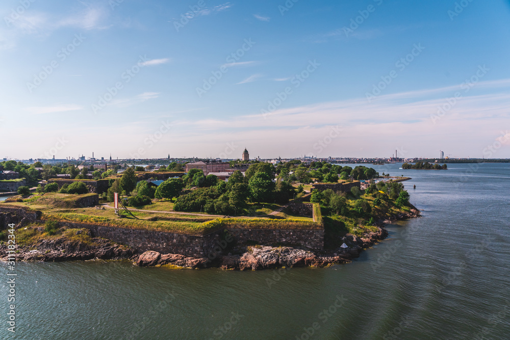 Suomenlinna fortress on a summer day with city behind it in distance, Helsinki Finland