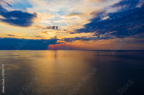Evening sky with setting sun over the sea. Shooting from a drone.
