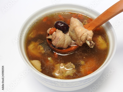 High angle view of a bowl of chicken soup isolated on white background. It contain Chinese medicine such as goji berry and red jujube. Warm, and nutritious . Taiwan food and winter food concept.