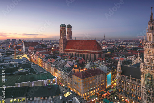 Aerial city view of Munich old town with skyline or cityscape and main cathedral in Christmas time after winter sunset sky.