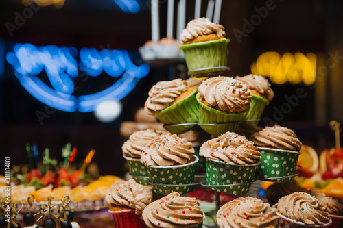 Freshly made cupcakes stand on a stand.