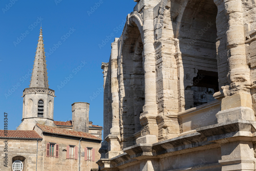 Close up of Arles Amphitheatre in Provence with Church spires in the background and French buildings