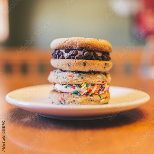 Two chocolate chip and sugar cookies stacked on a white plate