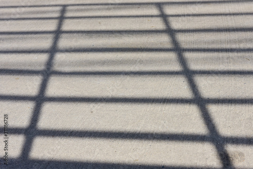 The shadow of car grille apper on the street.