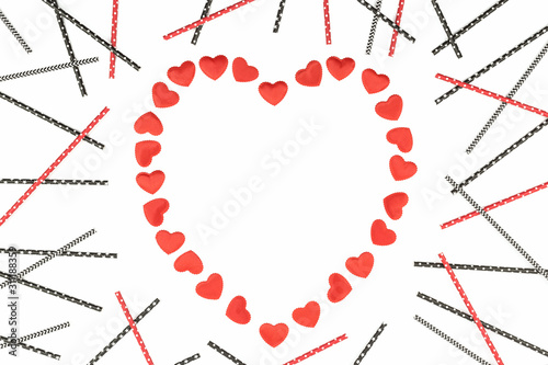 Small red fabric hearts frame monochrome isolated on white background with paper straws. 14 February. Passion, love and feelings St Valentine's Day Card celebration concept with copy space photo