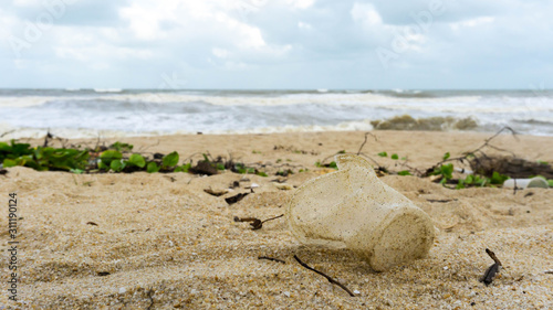 An empty plastic cup on the sandy beach at Batu Burok Beach in Kuala Terengganu. photo