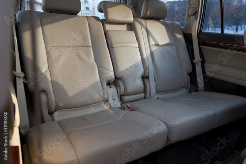 Clean after washing the rear passenger seats of beige genuine leather inside the interior of an expensive suv, preparation before selling the car. Auto service industry. detailing cleaning.