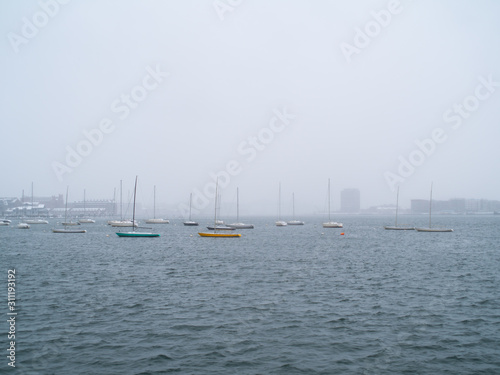 Small Sailing Ships Anchored In Boston Harbor On A Snowy Day