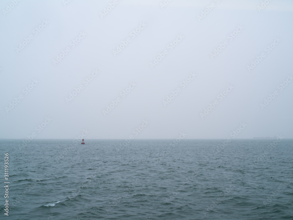 A Buoy Marks the Way on a Foggy Day in the Harbor