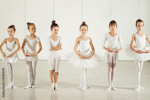 ballet, dance concept. Choreographic dance of group of caucasian graceful beautiful little ballerinas practicing together during classes in classical ballet school