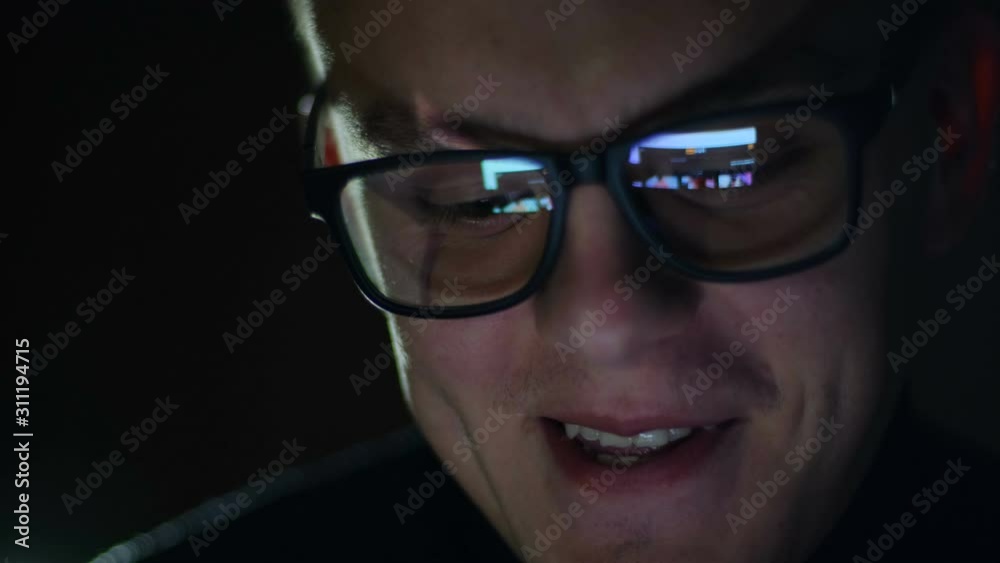Man watching nude content online on smartphone in reflection of glasses Man watching nude content online on smartphone in reflection of glasses