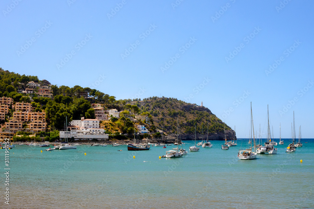 Soller, Spain, July 2019. Beautiful white rich yachts and boats in the city of Soller, Mallorca, Balearic Islands. Beautiful city on the background of the sea and mountains. Travel to sunny Spain.