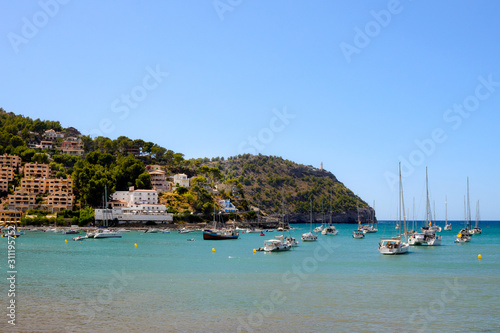 Soller, Spain, July 2019. Beautiful white rich yachts and boats in the city of Soller, Mallorca, Balearic Islands. Beautiful city on the background of the sea and mountains. Travel to sunny Spain.