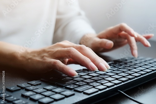 2 hands of Asian woman is press, typing on 2 language keyboard as Thai and English. Maybe preparation about information to report, chat to lover or shopping online by connect to internet at home, cafe
