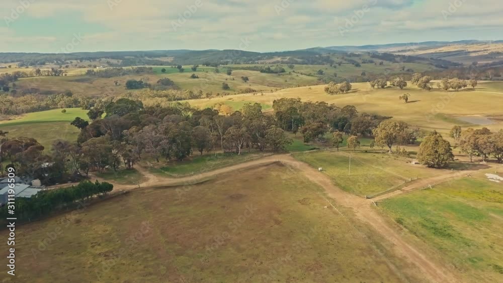 A cinematic aerial shot of rural farmlands in Australia with idyllic sunshine and dramatic clouds A cinematic aerial shot of rural farmlands in Australia with idyllic sunshine and dramatic clouds