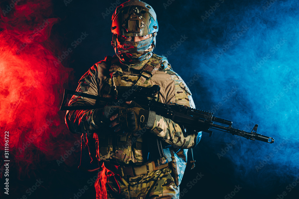 Naklejka premium powerful and strong military man in military forces wear and helmet pointing rifle at enemy, ready to shoot, fight for country, isolated in ultra violet space. army concept