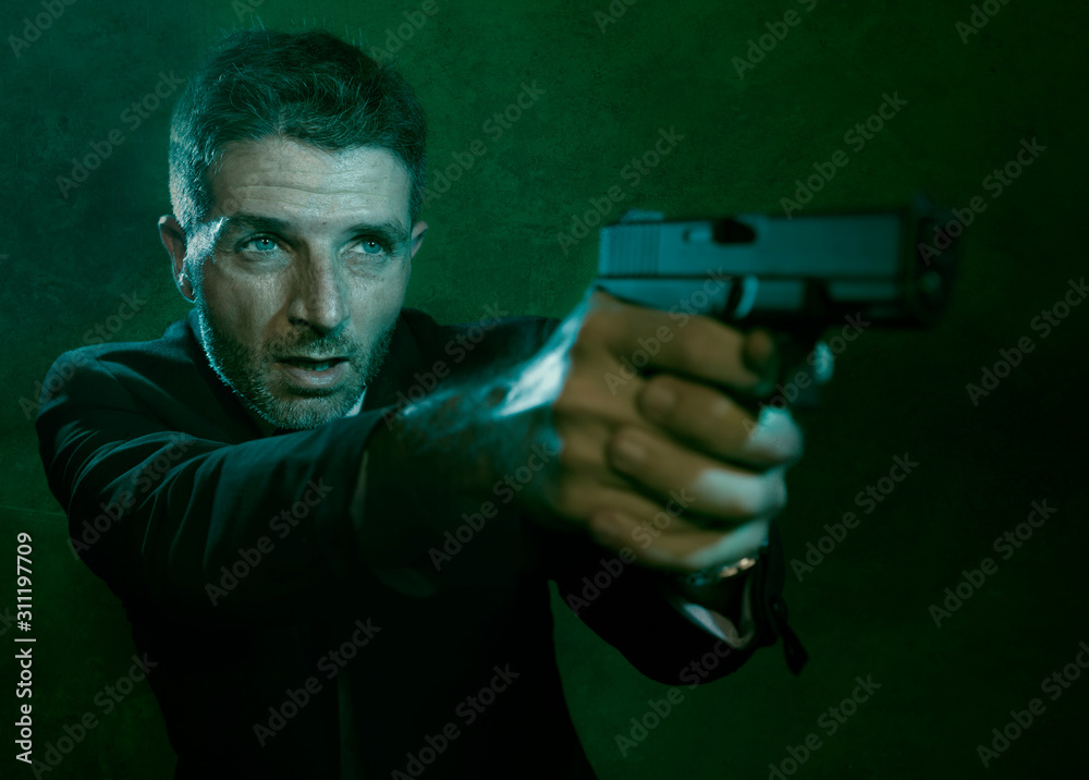 Man pointing handgun dramatic action portrait of attractive special agent or police officer aiming with gun in suit and tie holding the weapon serious in law enforcement Man pointing handgun dramatic action portrait of attractive special agent or police officer aiming with gun in suit and tie holding the weapon serious in law enforcement