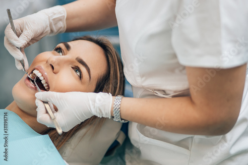 portrait of young blond good-looking woman on dental examination  treating teeth in professional orthodontic clinic