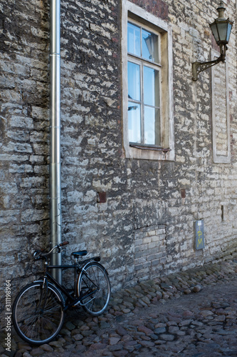 Black vintage bike at the stone wall of the old house