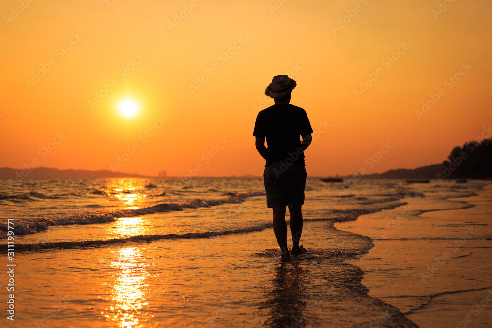 Young man walking on the beach. travel and relax concept.