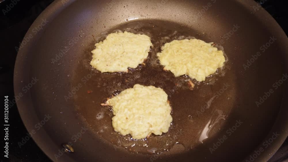 Potato pancakes known as latkes that are being fried in bubbling hot vegetable oil in a nonstick frying pan for the Jewish holiday of Hanukkah Potato pancakes known as latkes that are being fried in bubbling hot vegetable oil in a nonstick frying pan for the Jewish holiday of Hanukkah