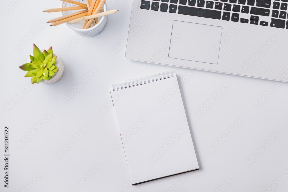 Flat lay composition with white laptop and mockup notepad on a white table - obrazy, fototapety, plakaty 