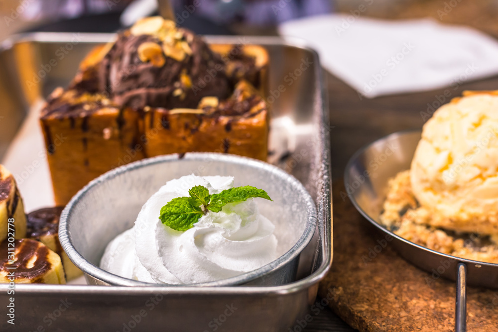White ice cream in plate on the wood near Toast bread with chocolate ice cream. White ice cream in plate on the wood near Toast bread with chocolate ice cream.