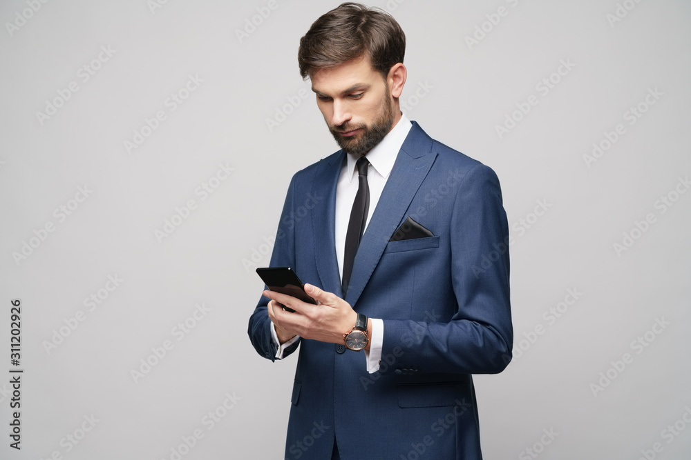 businessman holding phone isolated over grey background businessman holding phone isolated over grey background