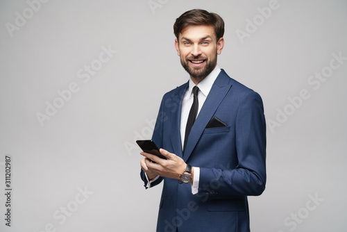 businessman holding phone isolated over grey background